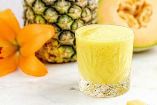 A tropical Pineapple Anti-Bloat Smoothie, with a creamy texture and bright yellow color, featuring pineapple and other natural ingredients to support digestion and reduce bloating.