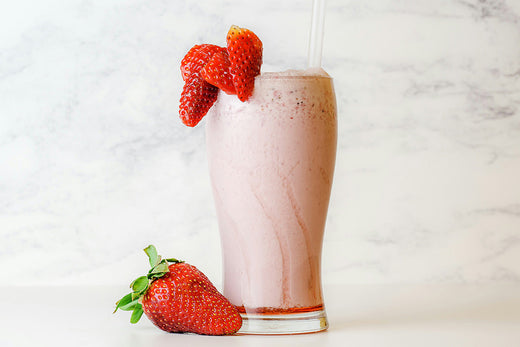 A vibrant pink Radiant Glow Strawberry Smoothie, packed with fresh strawberries and topped with a creamy texture, perfect for a refreshing and healthy treat.
